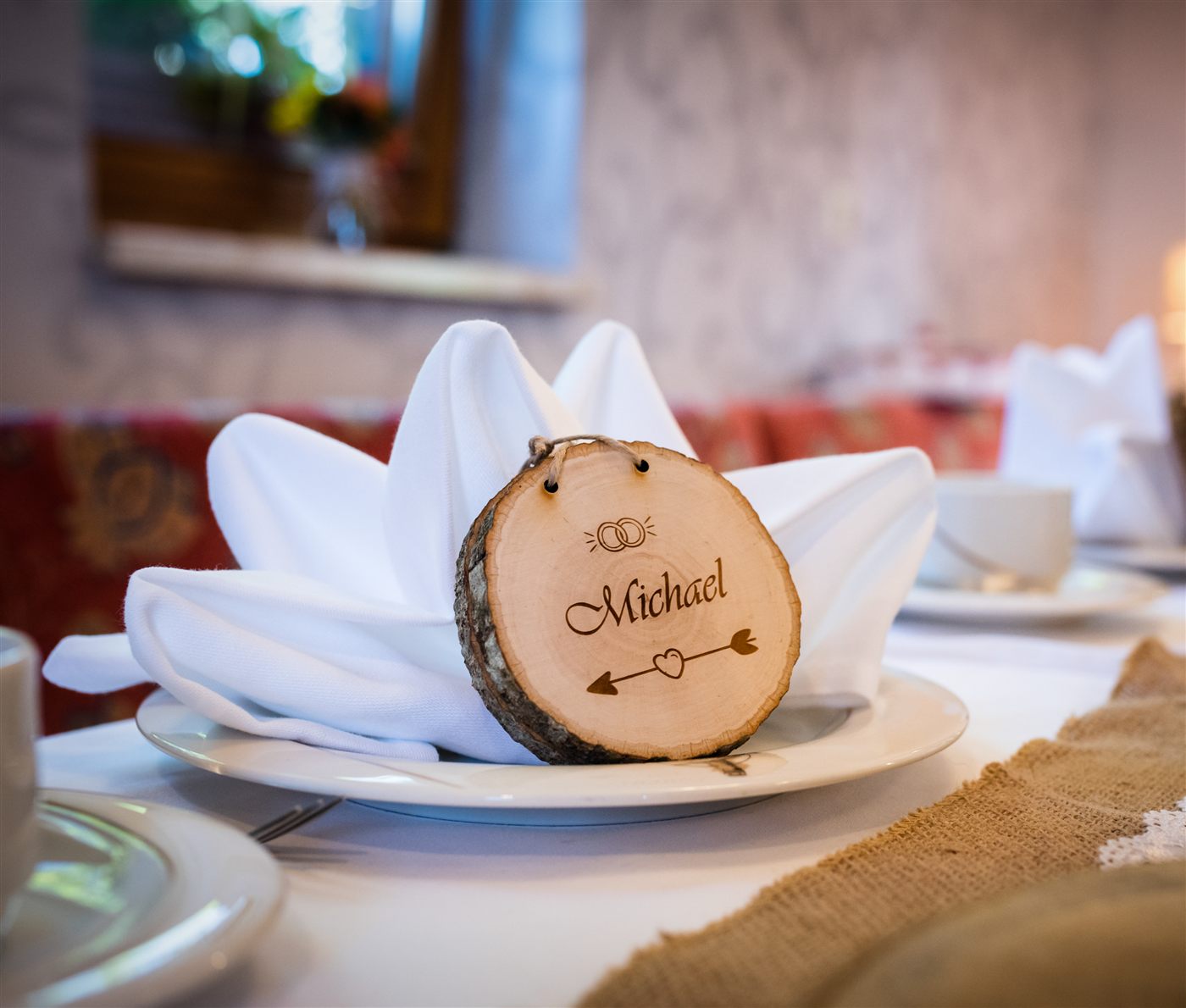 Personalisierte Gravur auf einer Baumscheibe als Namenskarte bei einer Hochzeit
